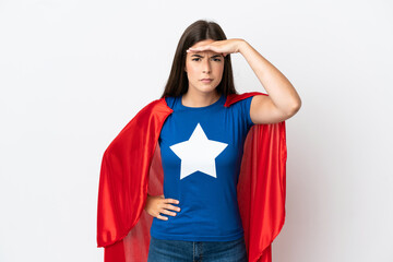 Young Brazilian woman isolated on white background in superhero costume and showing something