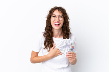 Young woman with curly hair taking a lot of money isolated background on white background smiling a lot