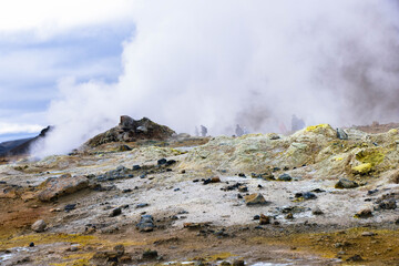 Hverir and myvatn geothermal spot with bubbling mud and steaming fumaroles emitting sulfuric gas.