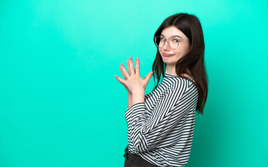 Young Russian woman isolated on green background scheming something