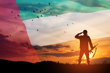 Silhouette of soldier saluting on background of UAE flag and the sunset or the sunrise. Concept of...