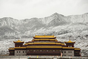 Beautiful shot of the Lama temple and snowy mountains in Sichuan, China
