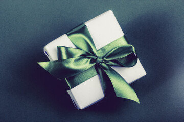 Gift box with green bow on dark background