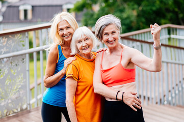 Active senior women doing fitness in a park - Sportive old people training outdoors