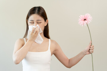 Hypersensitive allergiy concept, woman closes her nose prevent from seasonal flower pollen.