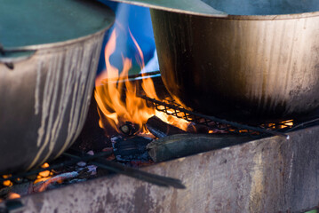 Burning fire between two cauldrons with food