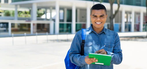 Young mexican male student with backpack and copy space