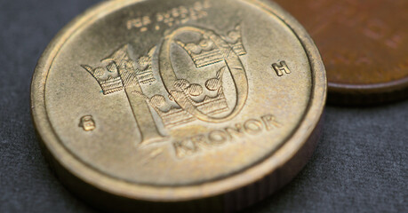 Swedish coins lie on dark surface. 10 ten krona coin close up. National currency of Sweden. Money...
