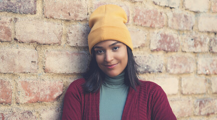 Smiling latin american young adult woman with bobble hat
