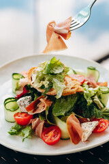 Salad blue cheese, prosciutto, arugula with spicy dressing on a light background. Healthy eating.