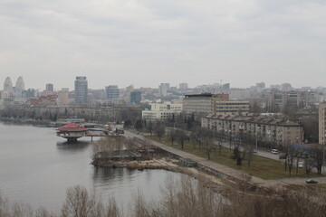 Naklejka premium View of the city and the Dnieper River. Autumn landscape of the city from a high roof. Sights and architects of a big city. The longest embankment in Europe in the city of Dnipro.