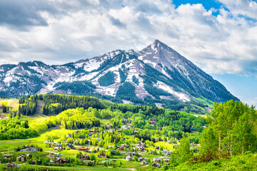 Mount Crested Butte city, ski resort town cityscape in Gunnison county with open panorama view of valley meadow in summer, houses homes