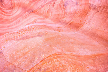 Macro closeup abstract red pink colorful sandstone rock formation layers of wave pattern on rock...