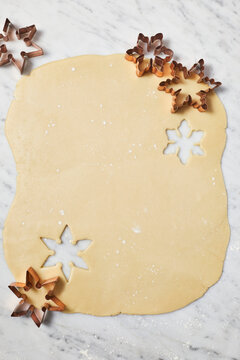Cookie dough rolled out on marble with star cutters