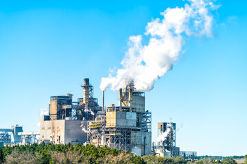 Industrial paper mill factory plant with chimney smokestacks stacks emitting carbon dioxide emission pollution in Georgetown, South Carolina town - obrazy, fototapety, plakaty