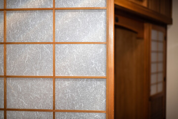 Traditional Japanese home house room or ryokan with closeup of open shoji sliding paper doors to empty room