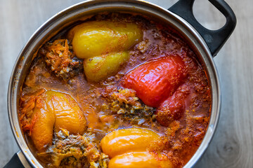 Macro closeup of traditional Russian or Ukrainian dish in sauce pan pot cooked stuffed pepper with rice, ground beef meat, tomato broth