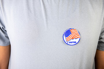 Closeup of person with I voted sticker label with stars stripes of American US flag on shirt after...