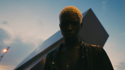 Portrait Of Black Guy In Night. Background Of Modern Building.