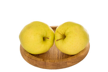 Two ripe yellow apples on a wooden plate, macro, isolated on a white background.
