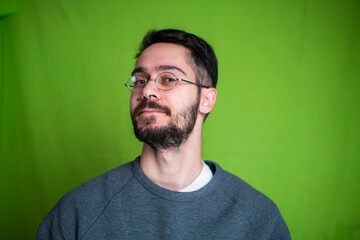 Young man with casual clothes, posing on green background