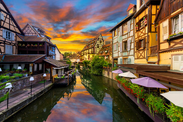 A colorful sunset above the Lauch river in the historic medieval Little Venice district of Colmar, France, in the Alsace region.