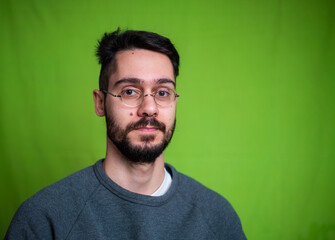 Fototapeta premium Young man with casual clothes, posing on green background
