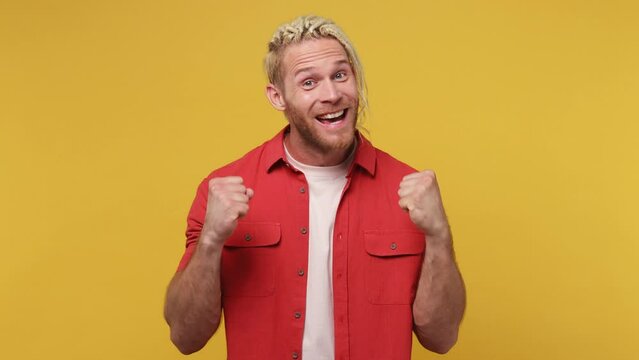 Young blond man with dreadlocks 30s he wear red shirt white t-shirt looking shocked surprised wow showing hands brain explosion head isolated on plain yellow background studio People lifestyle concept