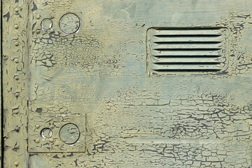 The exterior wall surface of the military helicopter is very old military green paint peeling off....