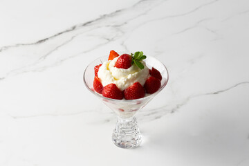 whipped cream with strawberries in a bowl on a light background