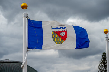 Flag of North West Territories waiving on a cloudy Canadian day.