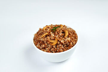 buckwheat porridge in a white plate with mushrooms on a plate, white background