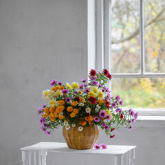 bouquet of colorful chrysanthemums in vase in white old interior