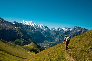 Fototapeta na wymiar Hiker standing on the Bernese Oberland hiking ridge with mountain landscape in Switzerland