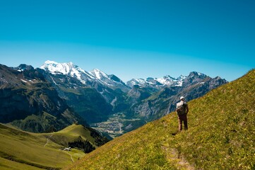 Fototapeta na wymiar Hiker standing on the Bernese Oberland hiking ridge with mountain landscape in Switzerland