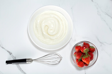 whipped cream and whisk on white background