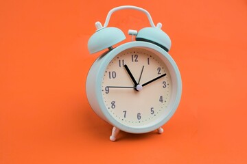 Closeup of an alarm clock on an orange background