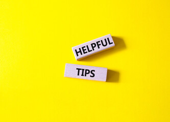 Helpful tips symbol. Wooden blocks with words Helpful tips. Beautiful yellow background. Business...