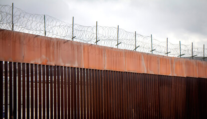 Border wall with barbed wire