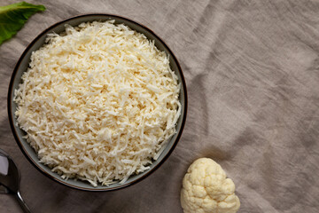 Organic Raw Cauliflower Rice in a Bowl, top view. Flat lay, overhead, from above. Copy space.