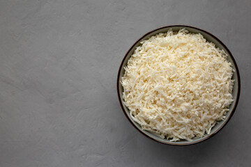 Organic Raw Cauliflower Rice in a Bowl on a gray background, top view. Flat lay, overhead, from above. Space for text.
