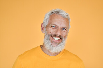 Happy mature old bearded man, smiling cool mid aged gray haired older senior hipster wearing yellow...