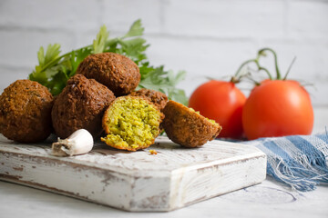 Falafel, tomatoes on a wooden background