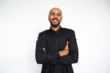 Portrait of confident young man crossing arms. Proud Latin American male model with bald head and...
