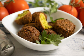 Falafel, tomatoes on a wooden background