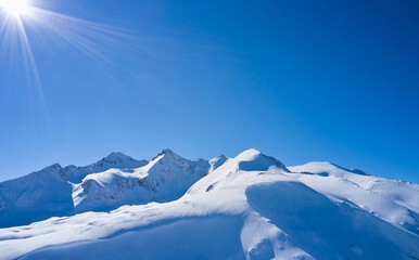 Snow covered mountain peak against the blue sky