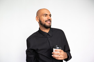 Portrait of confident young man with coffee. Self-assured African American male model with bald head in black shirt looking away, smiling while holding coffee cup. Advertisement, pleasure concept