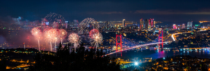 Fototapeta na wymiar Fireworks over Istanbul Bosphorus during Turkish Republic Day celebrations. Fireworks with 15th July Martyrs Bridge (Bosphorus Bridge). Istanbul, Turkey.