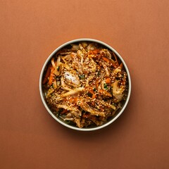 Top view shot of a bowl of food on an orange background