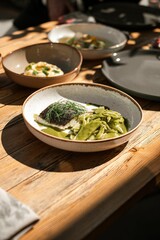 Vertical shot of green beans with fish in a bowl on a wooden table